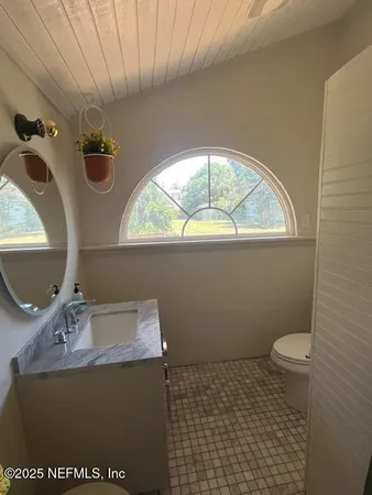 a bathroom with a sink a toilet and a mirror