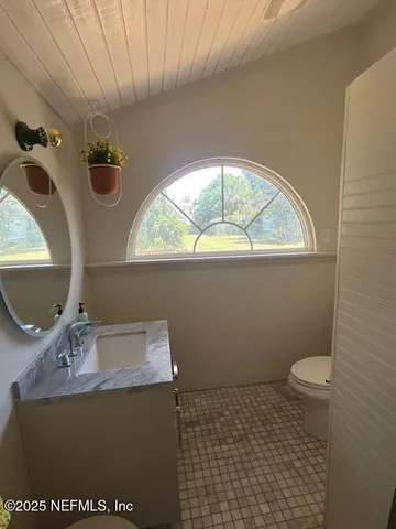 a bathroom with a sink a toilet and a mirror