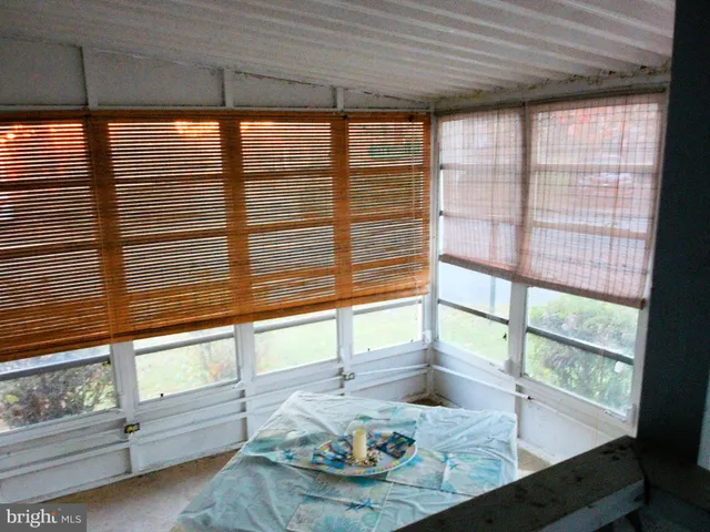 a view of a dining room with furniture and large windows