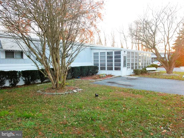 a front view of a house with a yard and trees