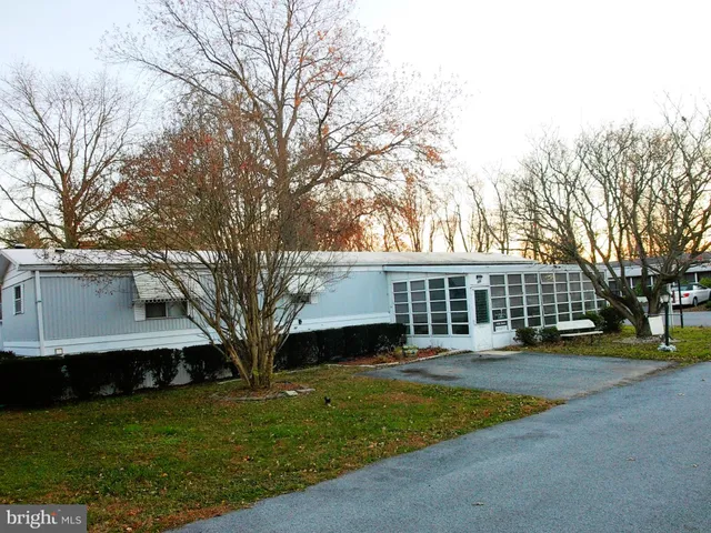 a front view of a house with a yard and trees