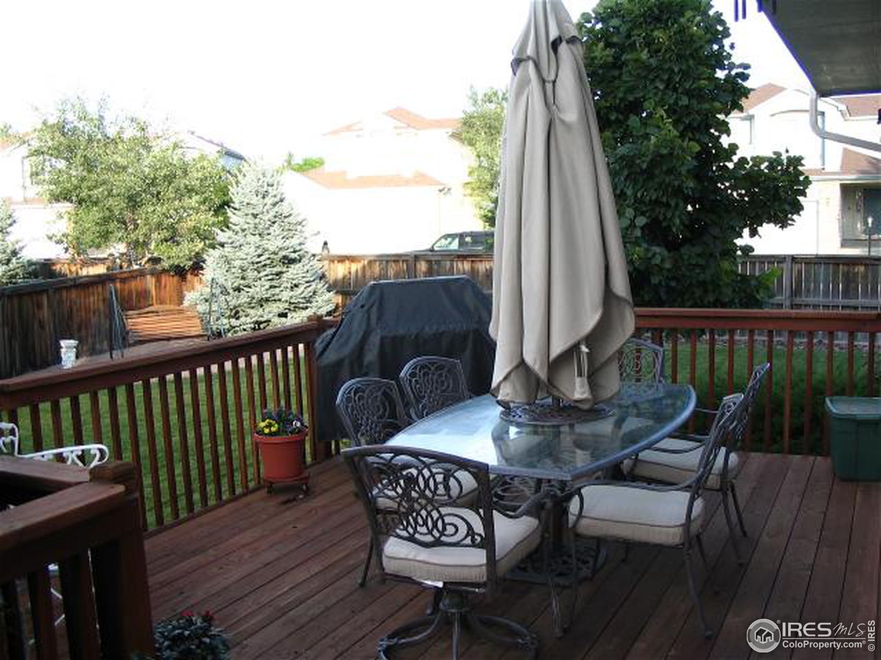 10015 Silver Maple Road Littleton, CO 80129 - Photo 2 of 11 a view of balcony with table and chairs and wooden fence