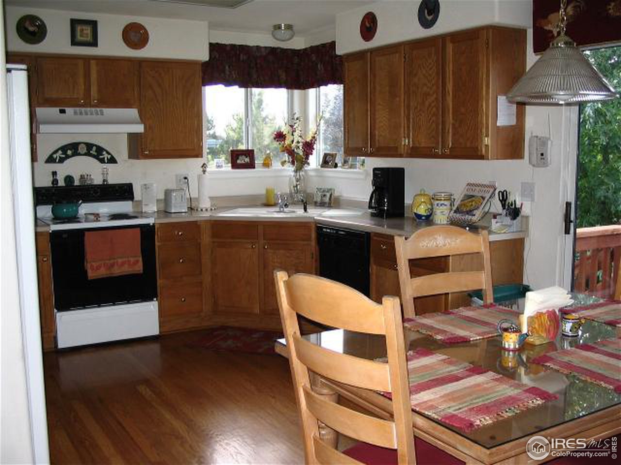 10015 Silver Maple Road Littleton, CO 80129 - Photo 4 of 11 a kitchen with stainless steel appliances granite countertop a stove top oven a sink dishwasher and cabinets with wooden floor