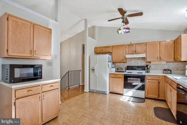 a kitchen with granite countertop a refrigerator stove top oven a sink and dishwasher