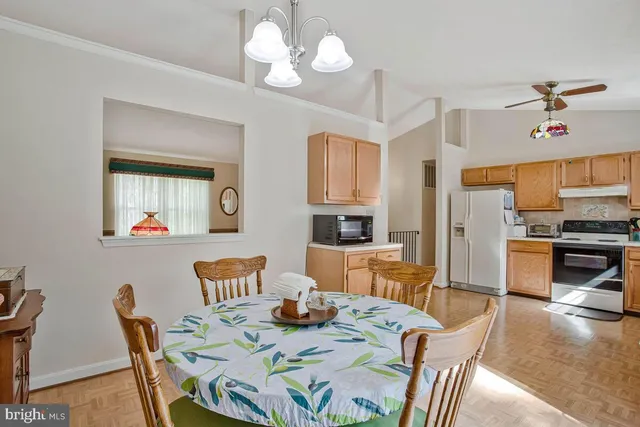 a view of a dining room with furniture a chandelier and wooden floor