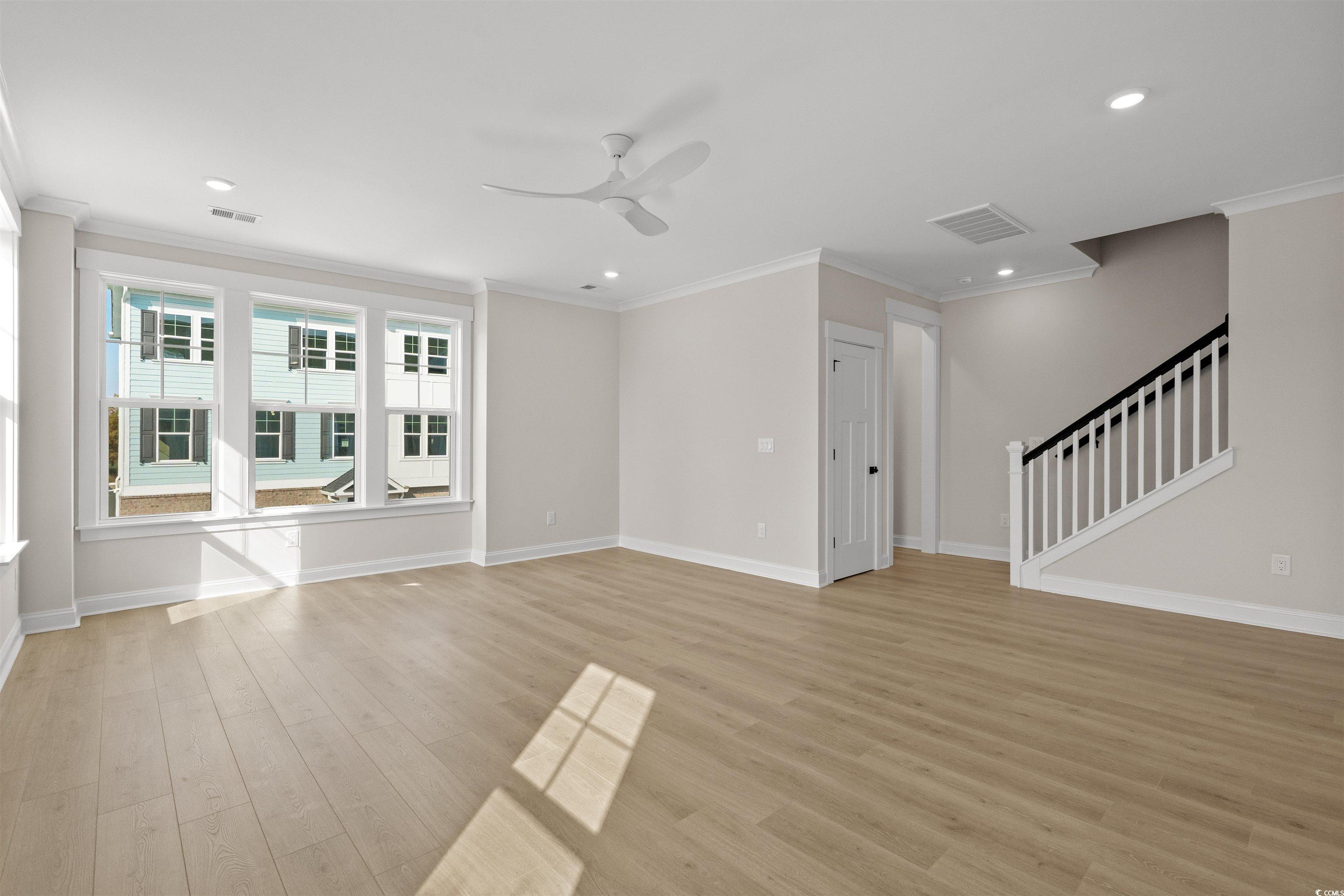 8476 Duke Place, Unit 32 Myrtle Beach, SC 29572 - Photo 13 of 40 Unfurnished living room with crown molding, stairway, light wood-style floors, a ceiling fan, and recessed lighting