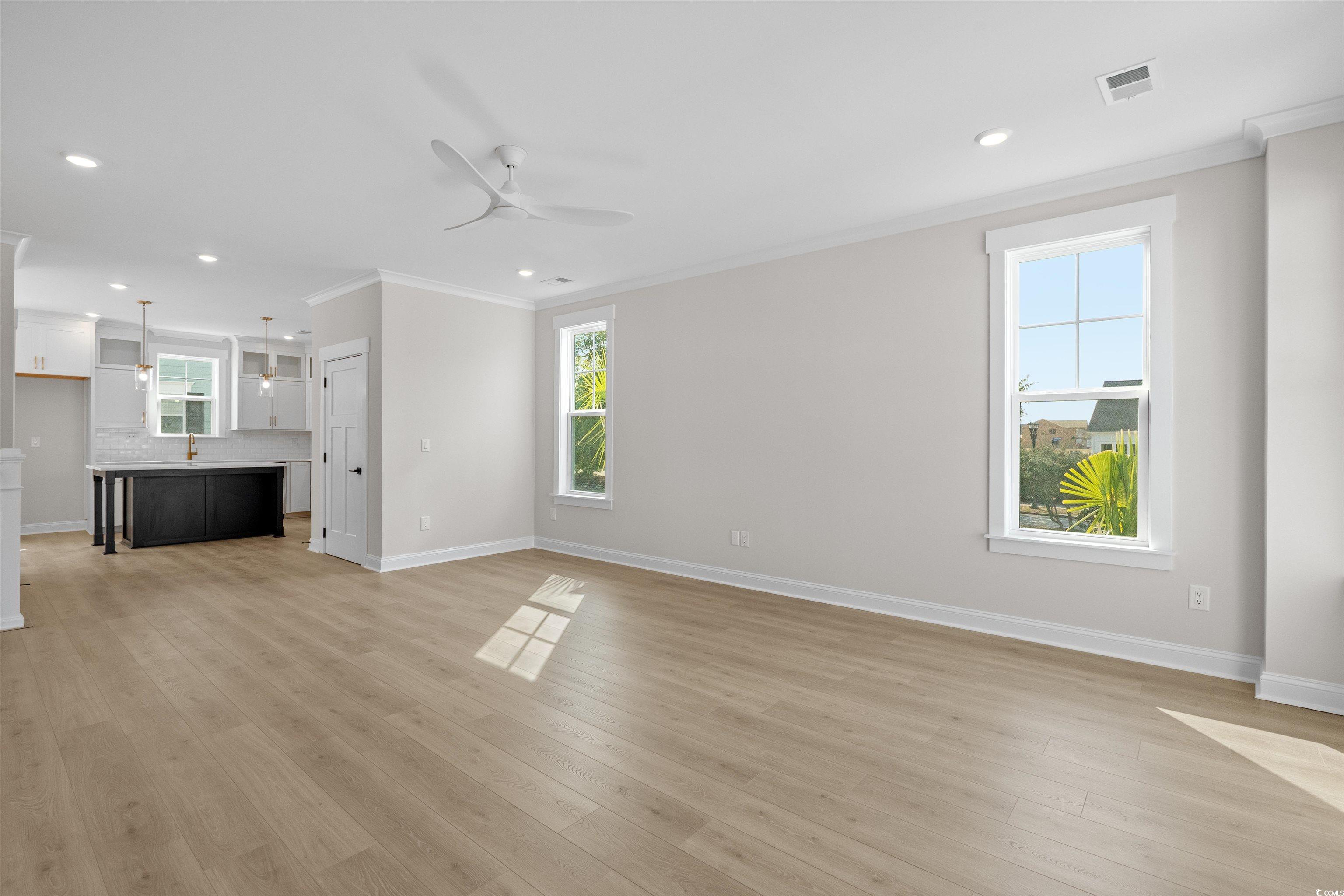 8476 Duke Place, Unit 32 Myrtle Beach, SC 29572 - Photo 15 of 40 Unfurnished living room featuring ornamental molding, plenty of natural light, recessed lighting, ceiling fan, and light wood-type flooring