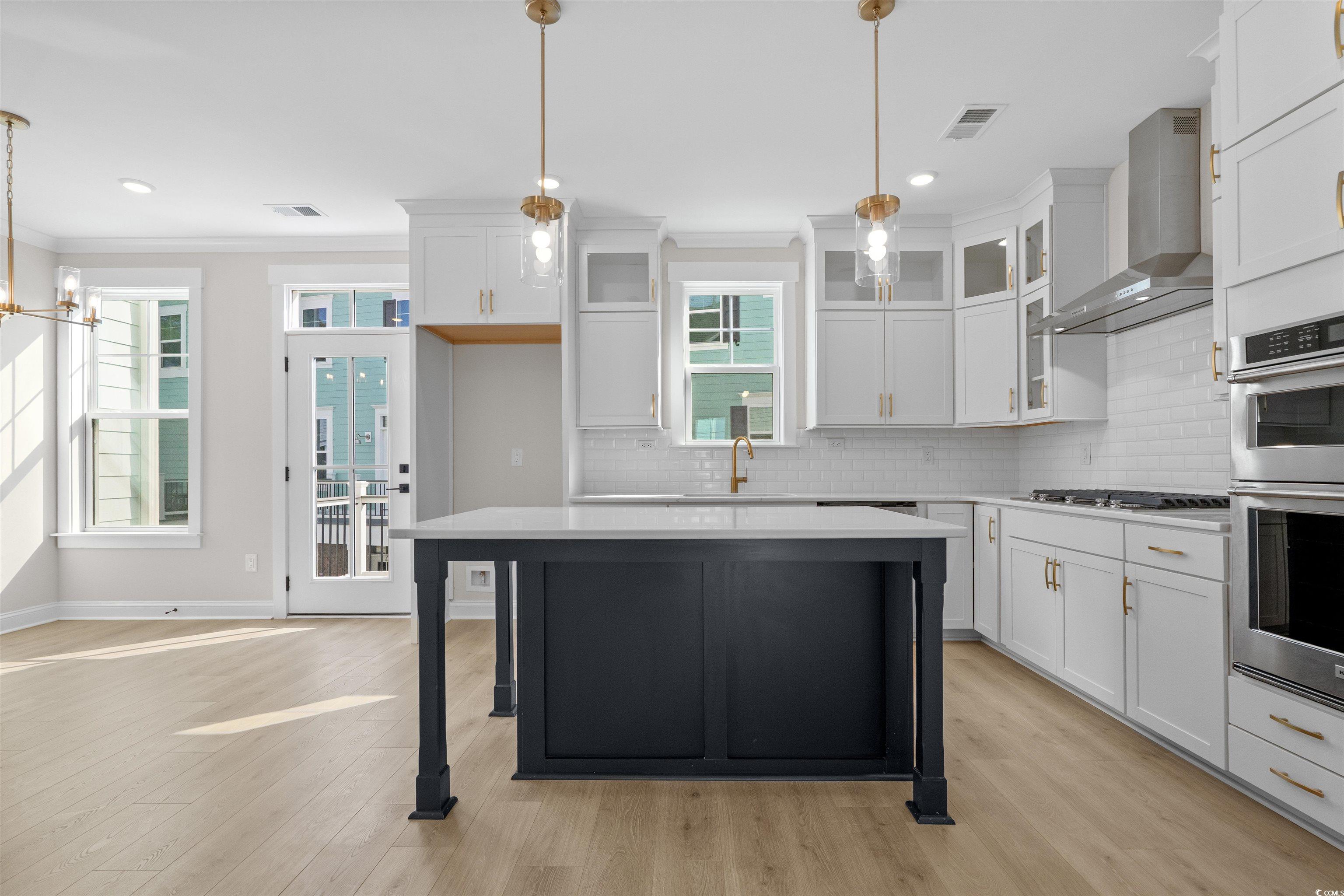 8476 Duke Place, Unit 32 Myrtle Beach, SC 29572 - Photo 6 of 40 Kitchen with decorative light fixtures, wall chimney exhaust hood, white cabinetry, ornamental molding, and recessed lighting