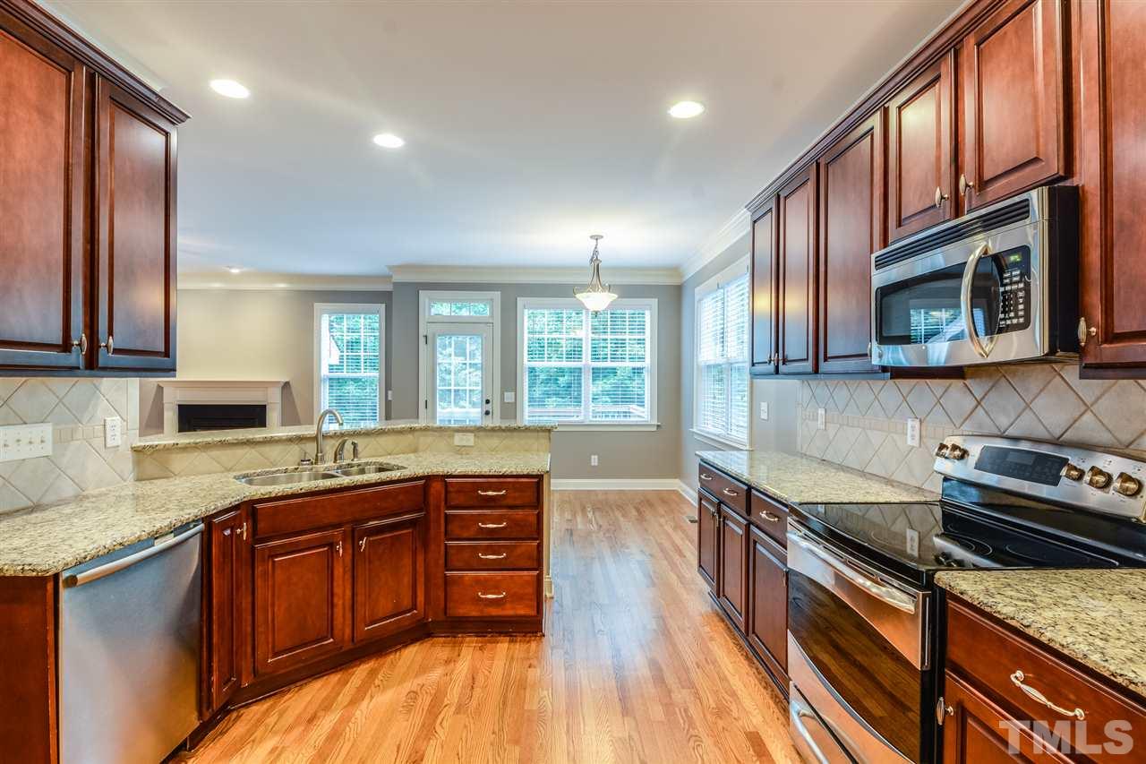 2261 Dunlin Lane Raleigh, NC 27614 - Photo 2 of 25 a kitchen with stainless steel appliances granite countertop wooden cabinets a stove top oven a sink and dishwasher