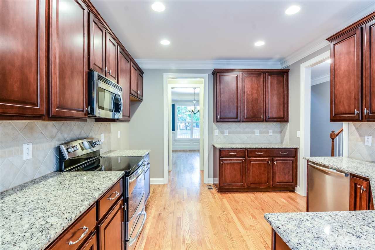 2261 Dunlin Lane Raleigh, NC 27614 - Photo 4 of 25 a kitchen with stainless steel appliances granite countertop wooden cabinets a stove top oven a sink and dishwasher