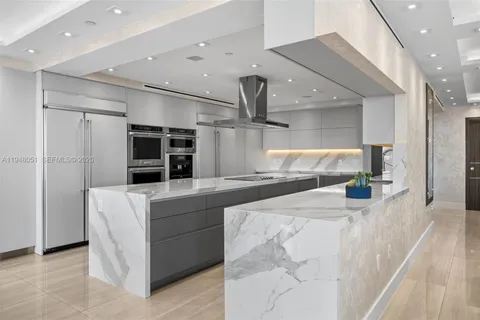 a kitchen with stainless steel appliances kitchen island a large counter top and a refrigerator