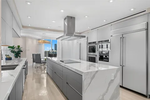 a kitchen with stainless steel appliances kitchen island a refrigerator and a sink