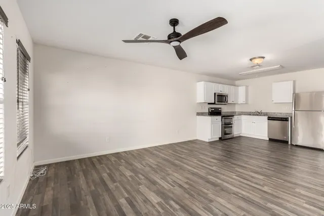 a view of kitchen with wooden floor electronic appliances and window