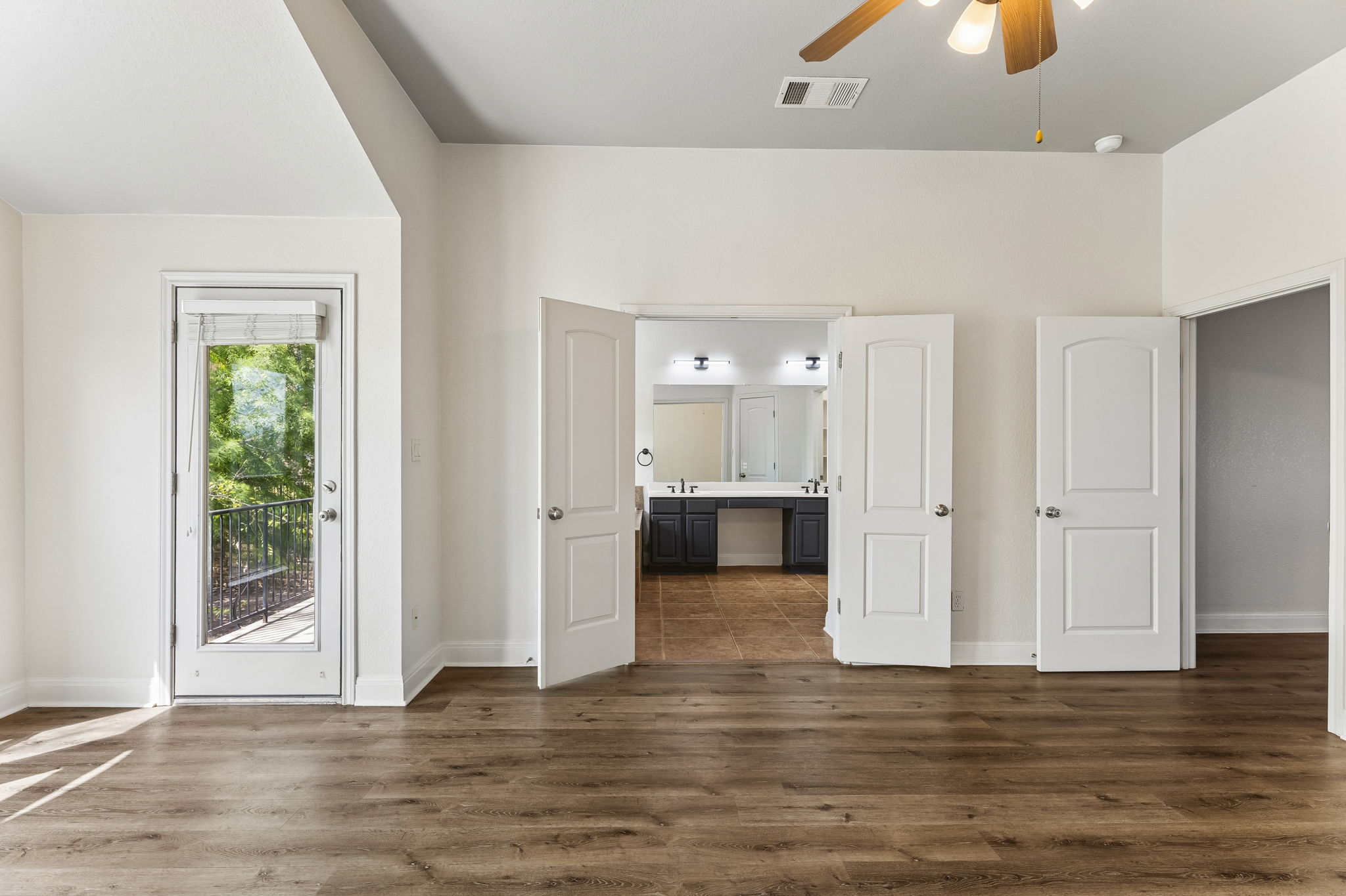 114 Aria Ridge, Unit 802 Lakeway, TX 78738 - Photo 29 of 37 Rich hardwood-style flooring extends throughout this generous primary bedroom, offering balcony access and an adjoining primary bathroom.