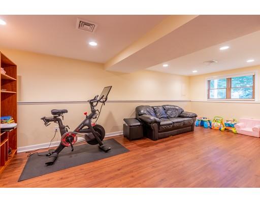833 Edgell Road Framingham, MA 01701 - Photo 19 of 24 a living room with furniture a flat screen tv and a gym equipment