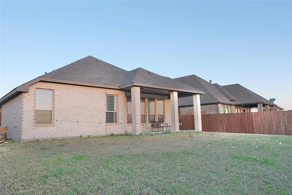 a view of a house with a yard and wooden fence