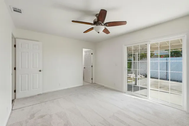 an empty room with closet and windows