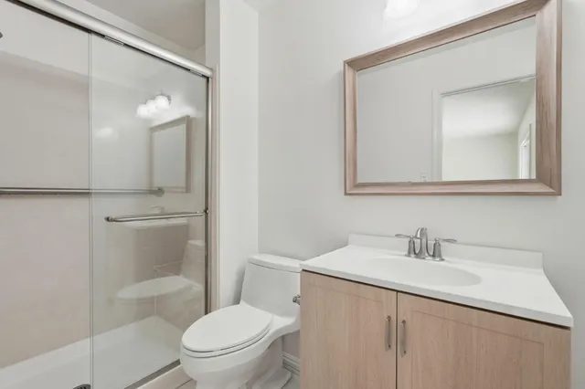 a bathroom with a toilet sink vanity and mirror
