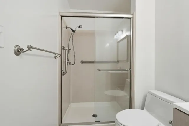 a bathroom with a shower a toilet and a sink