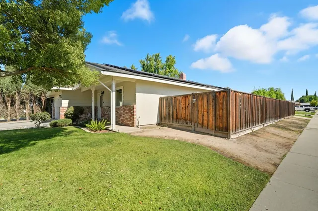 a view of a house with backyard and a tree