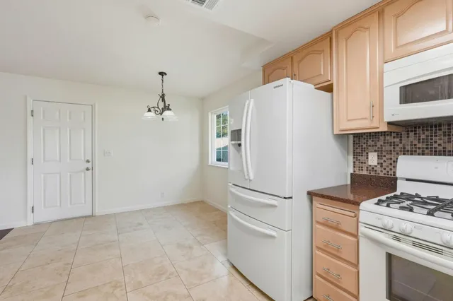 a kitchen with a stove top oven and refrigerator