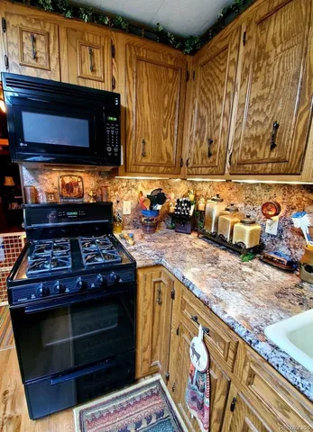 a living room with stainless steel appliances kitchen island granite countertop furniture a rug and a window