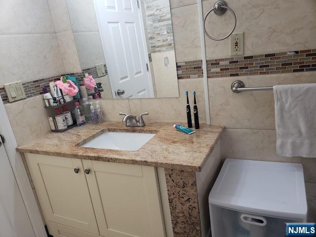 99 Knickerbocker Road Demarest, NJ 07627 - Photo 9 of 10 a bathroom with a granite countertop sink a mirror and vanity
