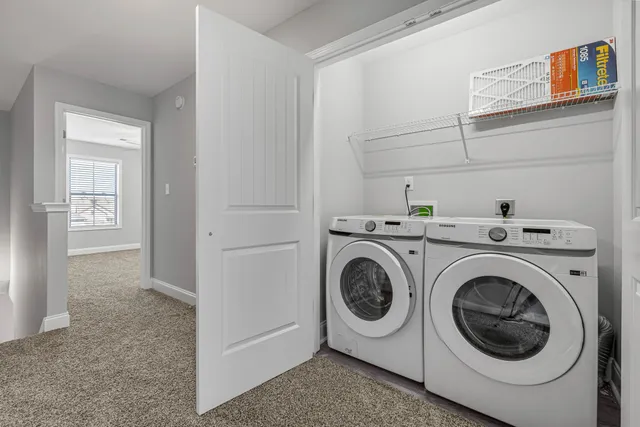 an empty room with a chandelier fan and windows