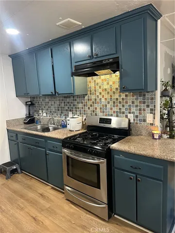 a kitchen with granite countertop a stove sink and cabinets