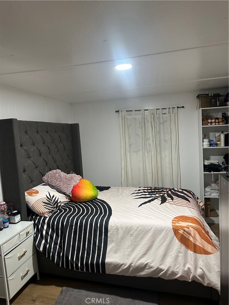 250 North Linden Avenue, Unit 148 Rialto, CA 92376 - Photo 9 of 17 a bedroom with a bed and painting on the wall