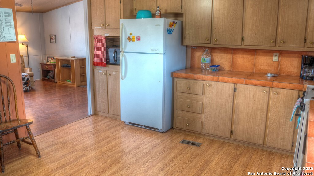 560 Pine Mountain Road Camp Wood, TX 78833 - Photo 11 of 38 a kitchen with refrigerator and cabinets