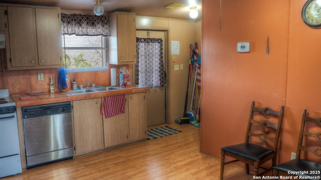 560 Pine Mountain Road Camp Wood, TX 78833 - Photo 13 of 38 a kitchen with a wooden floor and cabinets
