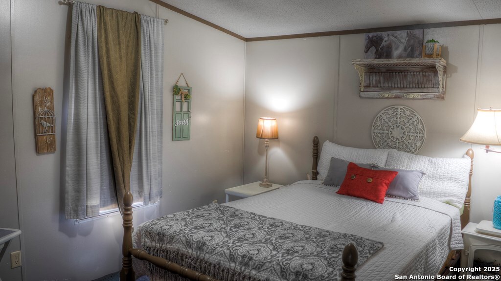 560 Pine Mountain Road Camp Wood, TX 78833 - Photo 19 of 38 a bedroom with a bed and wooden floor