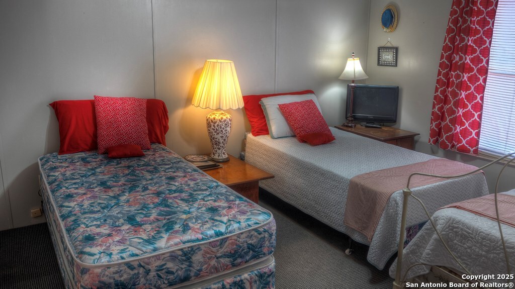 560 Pine Mountain Road Camp Wood, TX 78833 - Photo 21 of 38 a bedroom with a bed lamp and a potted plant