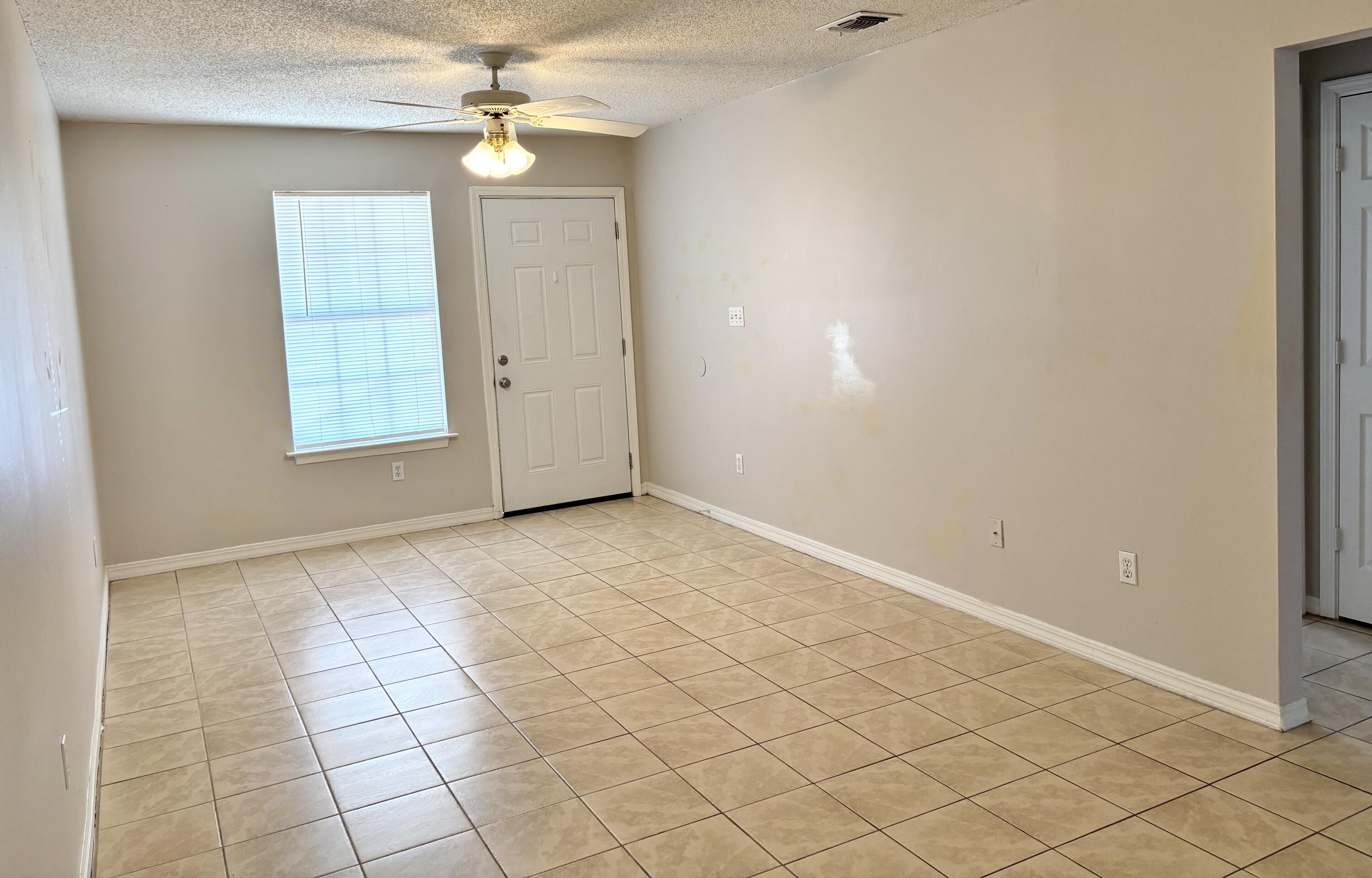 6903 Sea Turtle Circle, Unit A Navarre, FL 32566 - Photo 3 of 9 an empty room with windows and fan