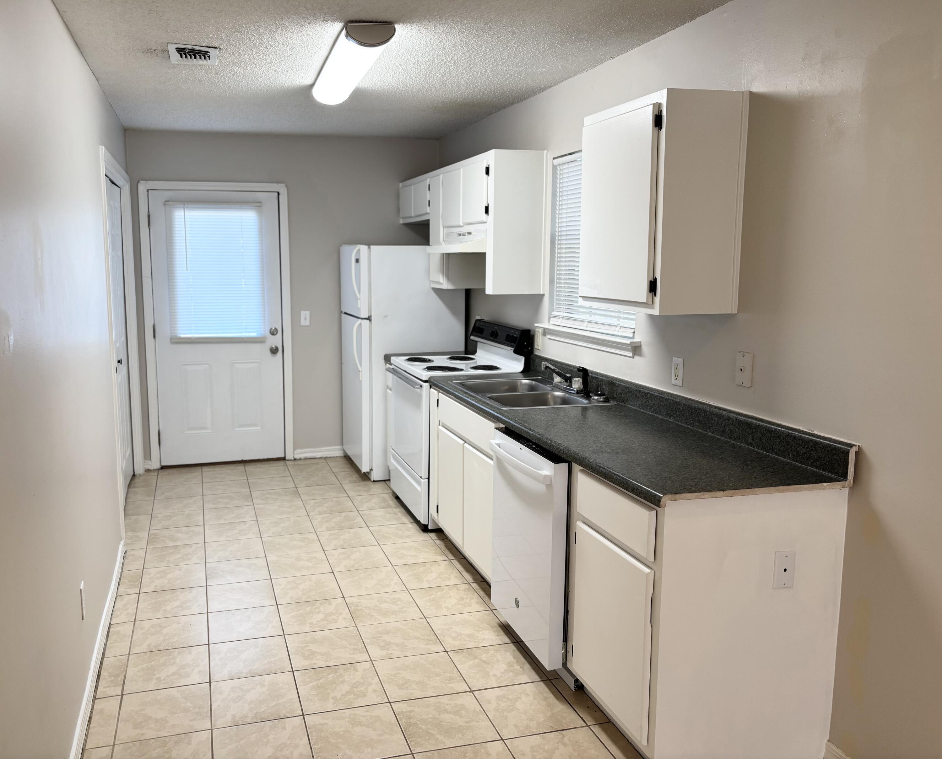 6903 Sea Turtle Circle, Unit A Navarre, FL 32566 - Photo 4 of 9 a kitchen with a stove a sink and a refrigerator