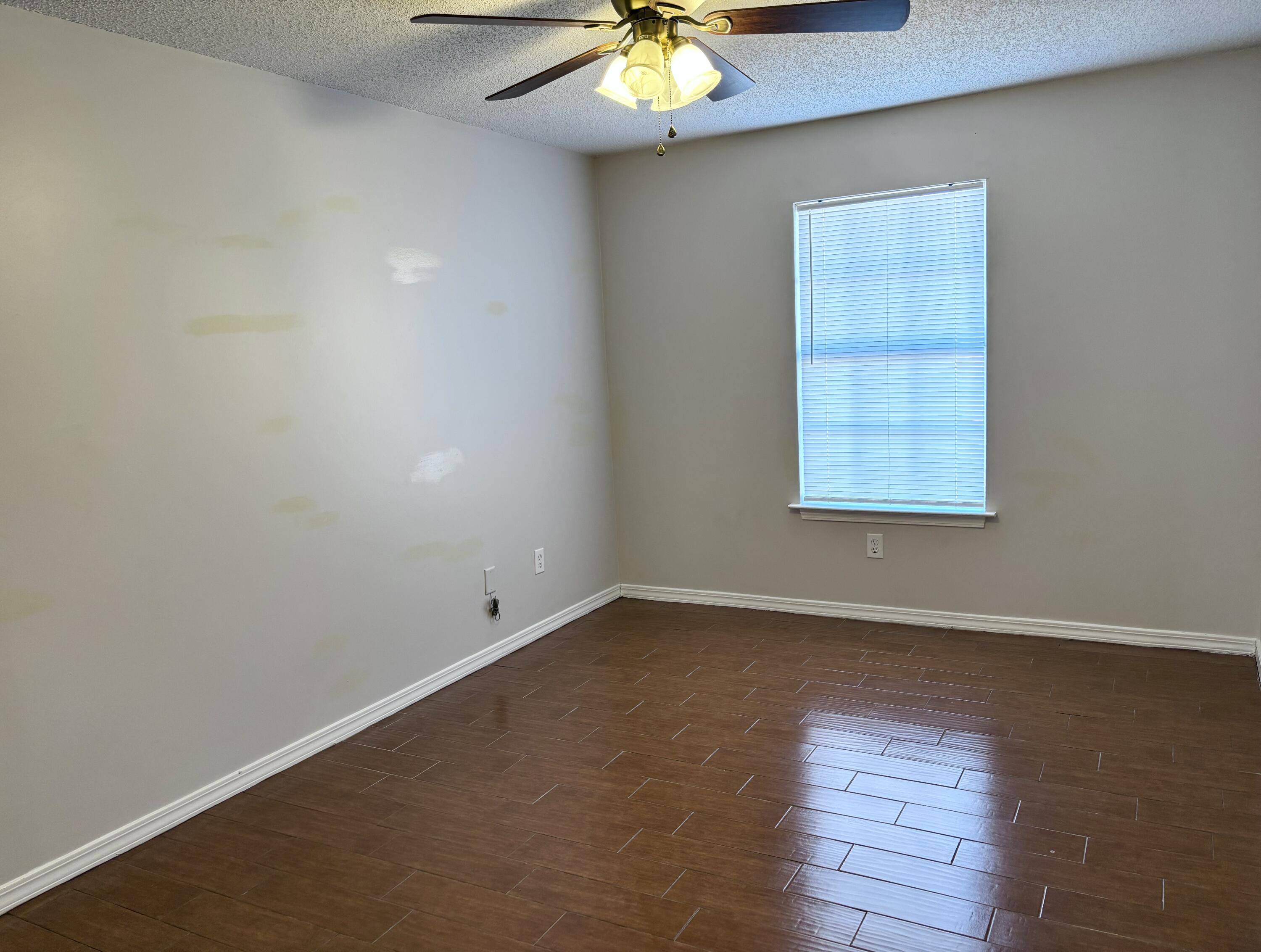 6903 Sea Turtle Circle, Unit A Navarre, FL 32566 - Photo 5 of 9 an empty room with wooden floor and windows