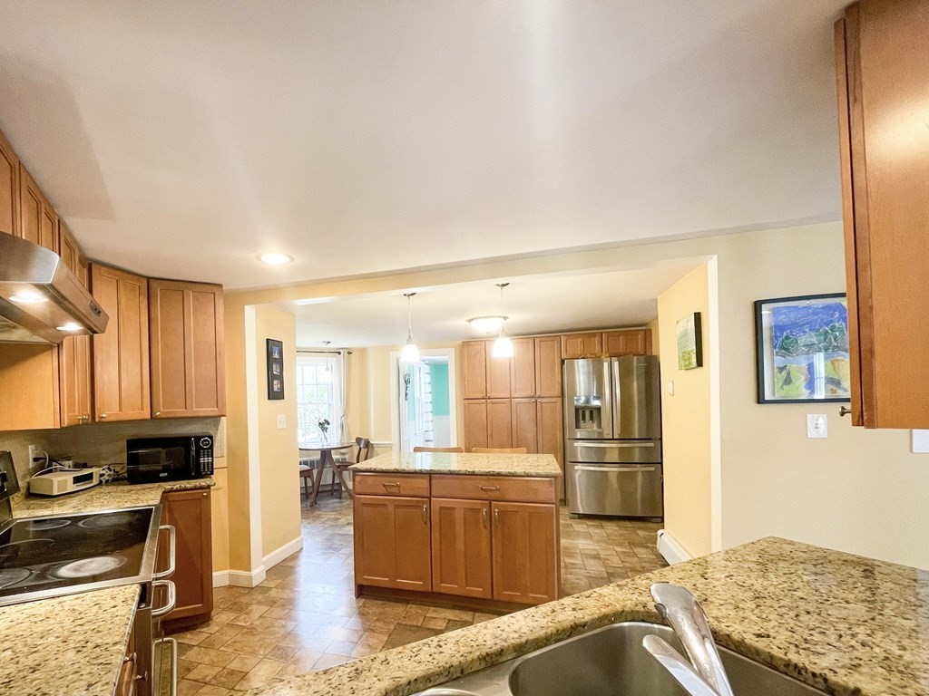 526 Quinobequin Road Newton, MA 02468 - Photo 23 of 42 a kitchen with stainless steel appliances granite countertop a sink stove and refrigerator
