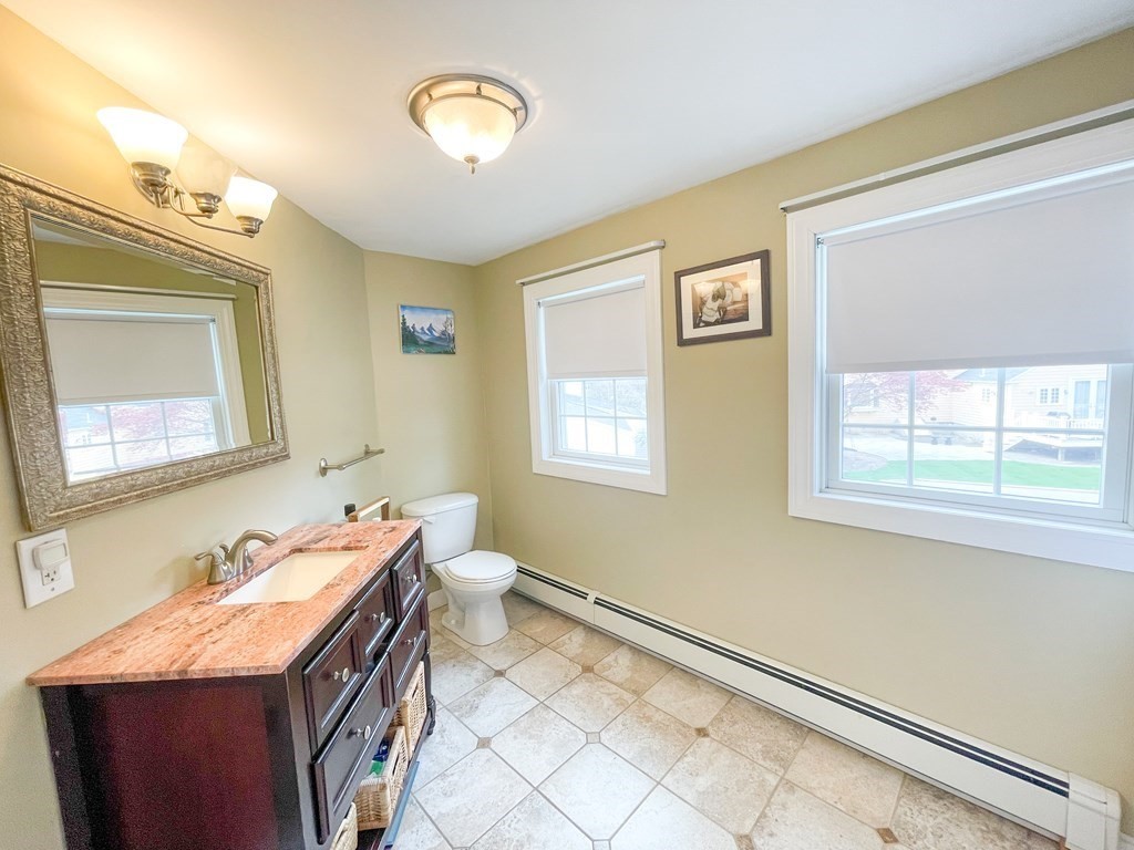 526 Quinobequin Road Newton, MA 02468 - Photo 33 of 42 a bathroom with a granite countertop sink mirror vanity and a toilet