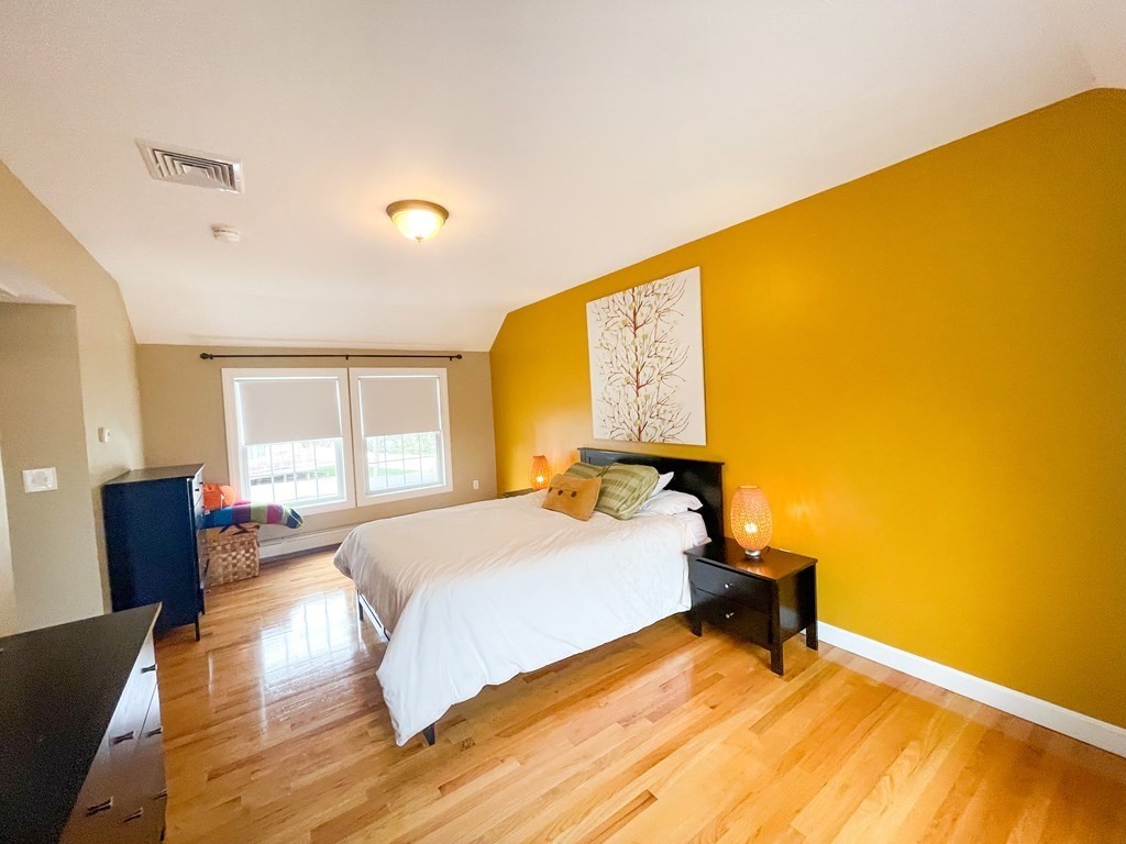 526 Quinobequin Road Newton, MA 02468 - Photo 36 of 42 a bedroom with a bed and wooden floor