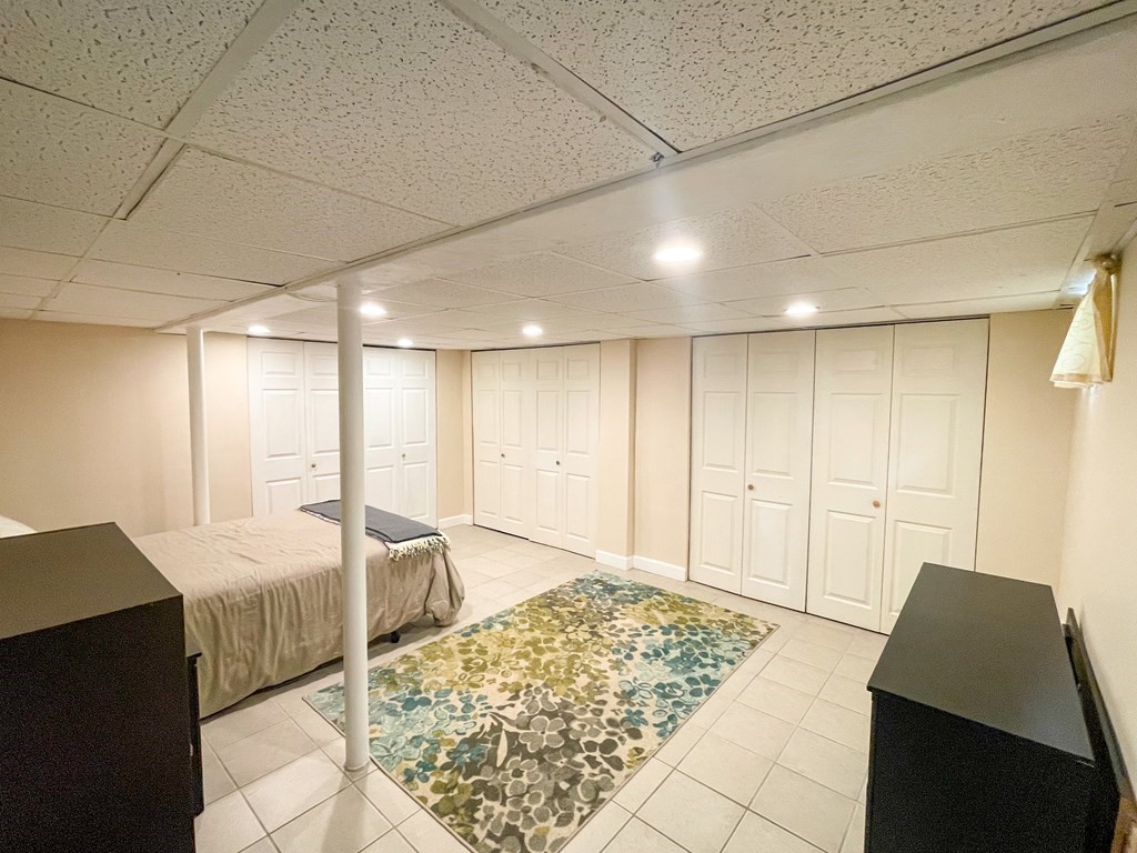 526 Quinobequin Road Newton, MA 02468 - Photo 37 of 42 a spacious bedroom with a bed and a walk in closet