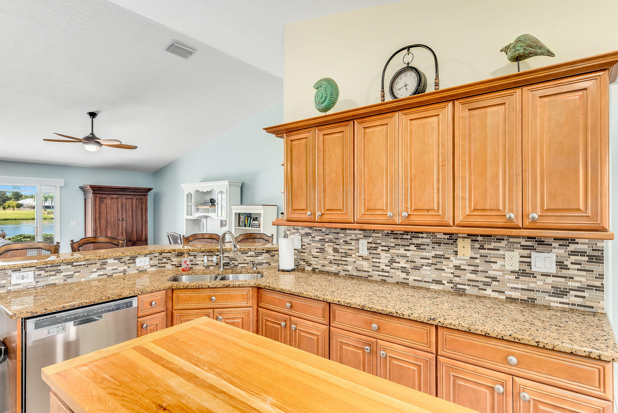 1566 Eagles Circle Sebastian, FL 32958 - Photo 23 of 74 a kitchen with granite countertop a sink stainless steel appliances white cabinets and granite counter tops