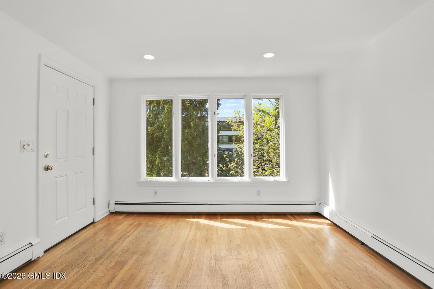 22 Grigg Street, Unit 2 Greenwich, CT 06830 - Photo 7 of 11 an empty room with wooden floor and windows