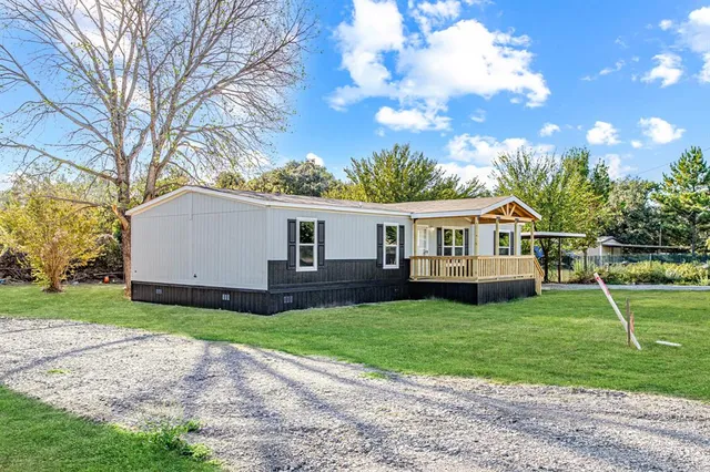 a front view of a house with yard and green space