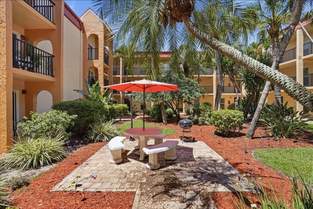 8911 Blind Pass Road, Unit 118 St. Pete Beach, FL 33706 - Photo 11 of 34 a view of a backyard with a patio and swimming pool