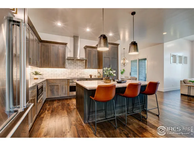 a open kitchen with stainless steel appliances kitchen island granite countertop a sink table and chairs