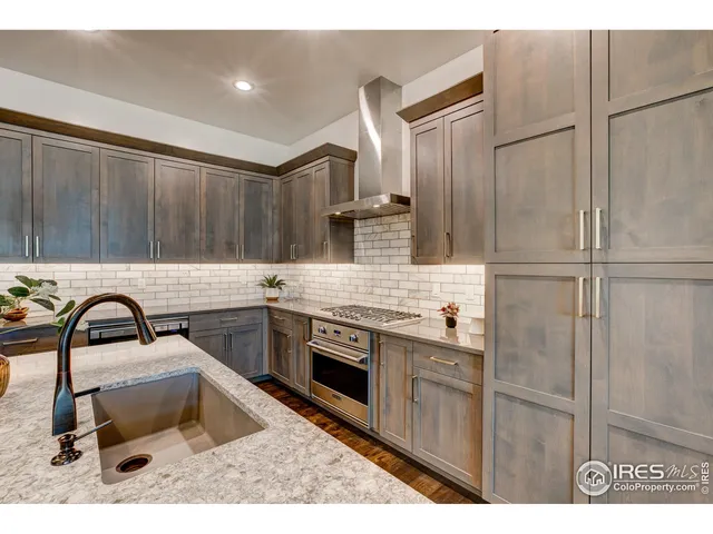 a kitchen with kitchen island granite countertop a sink stainless steel appliances and cabinets