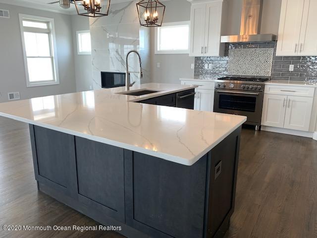 125 Shore Drive Brick, NJ 08723 - Photo 43 of 83 a kitchen with a sink dishwasher a stove and a refrigerator with wooden floor