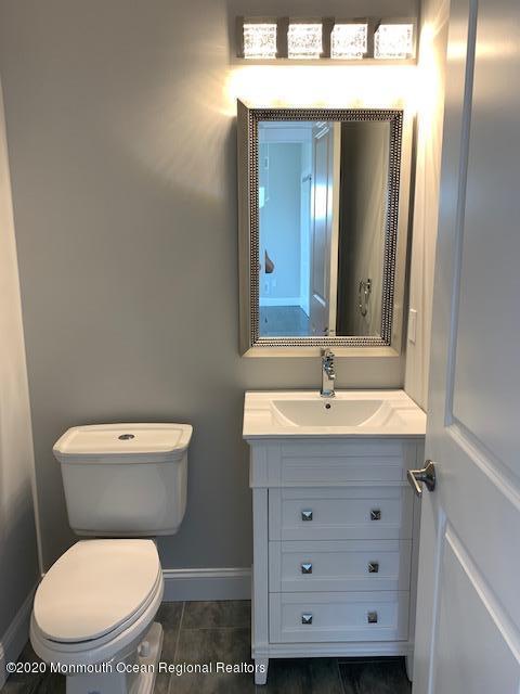 125 Shore Drive Brick, NJ 08723 - Photo 61 of 83 a bathroom with a granite countertop toilet sink and mirror