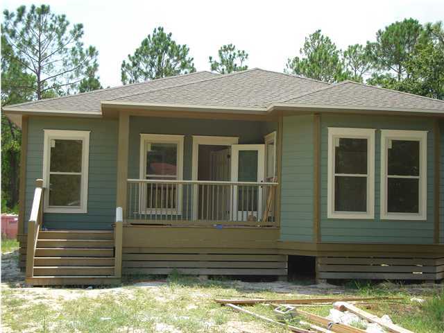 a view of a house with a large window and wooden fence